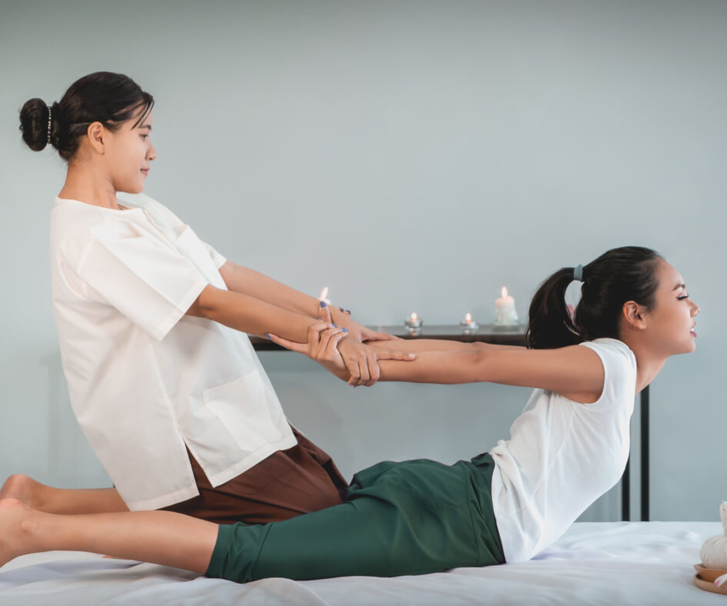 Woman is receiving Back Massage Stretching in Thai Therapy Spa treament.