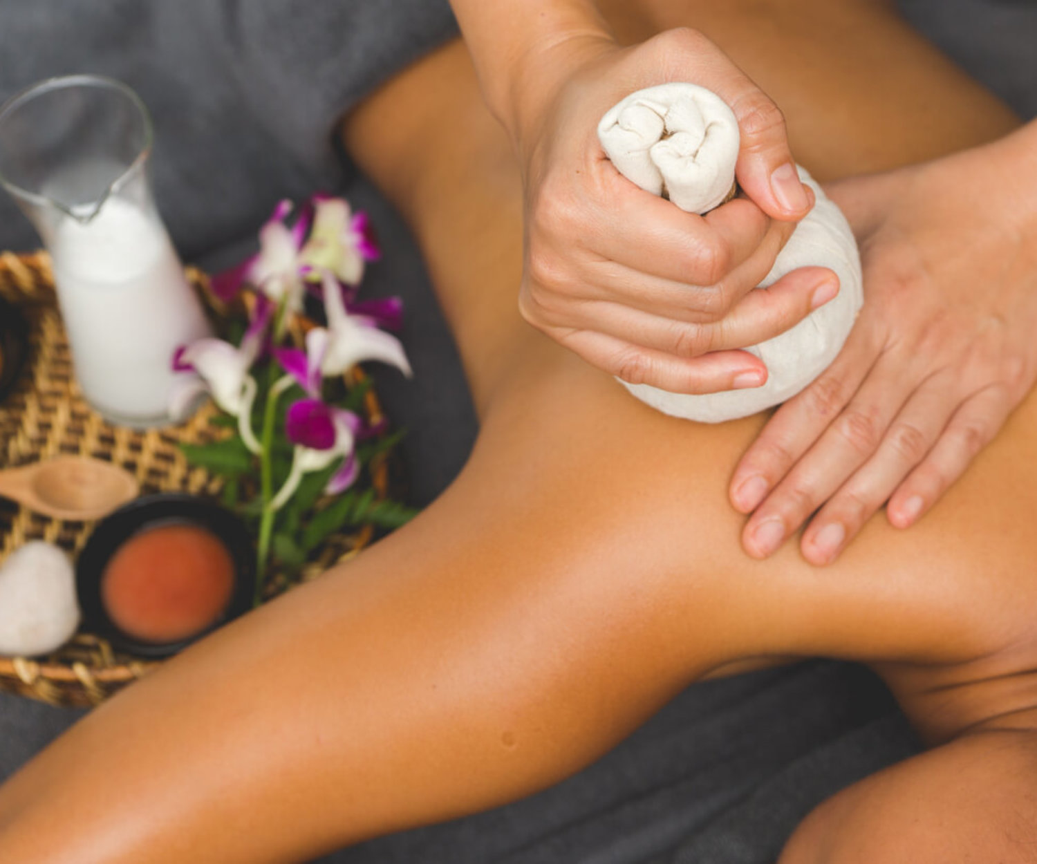 Thai Massage of  asian woman in spa room. Beautiful young woman having massage with herbal compress balls in therapy spa salon.